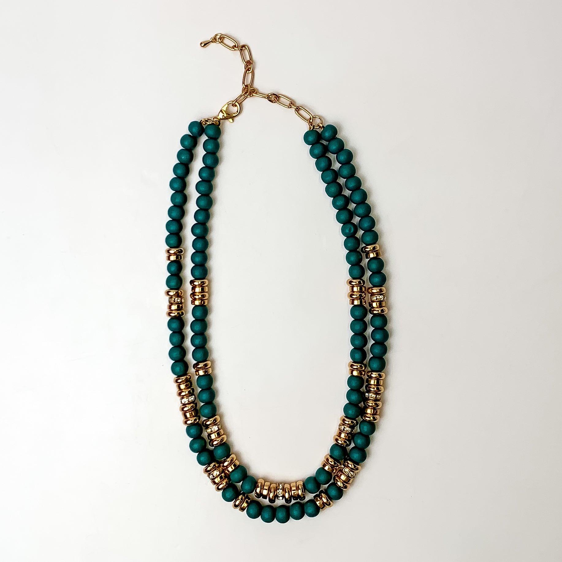 This layered necklace in deep blue has gold spacers. It is taken with a white background.