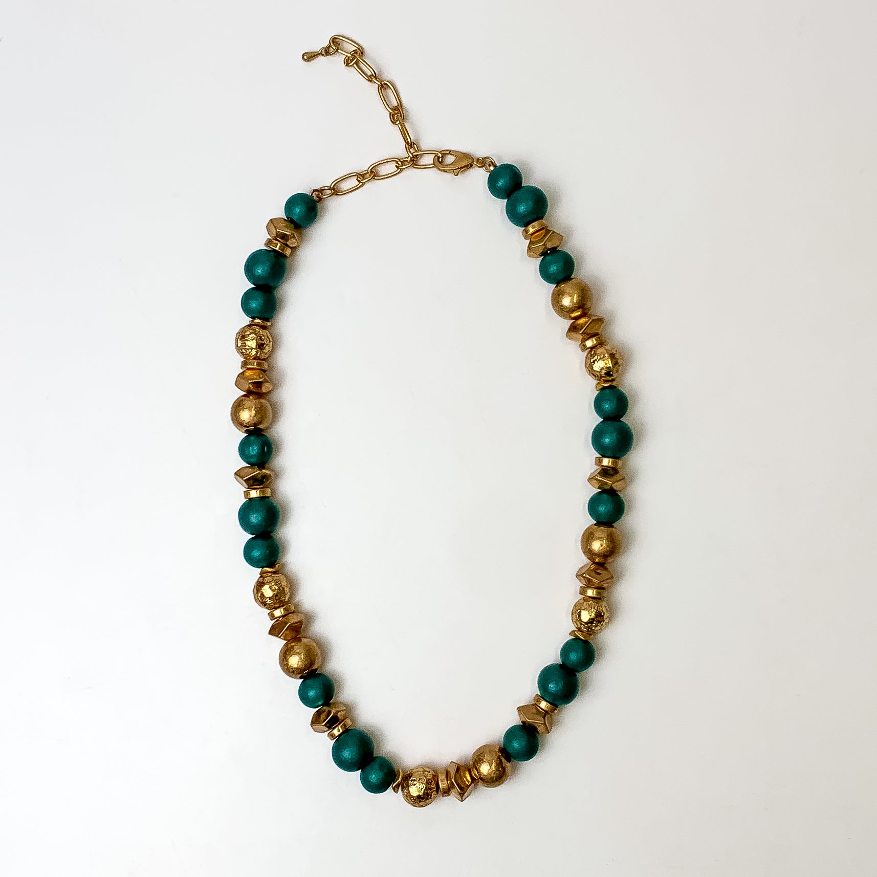 This texture beaded necklace with gold tone and chlorine blue beads are placed on a white background.