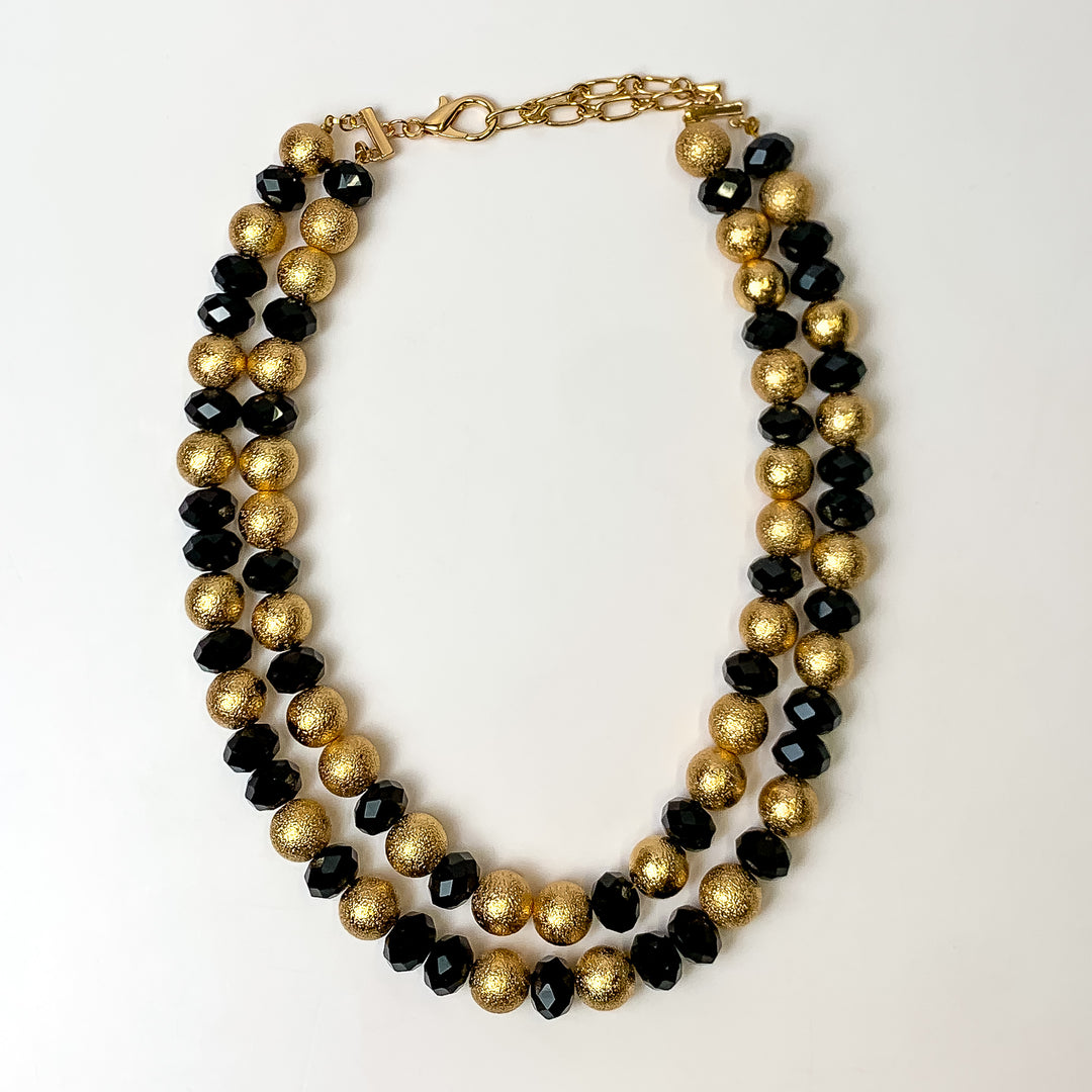This Bold Statement Layered Necklace in Gold Tone and Black is pictured on a white background.