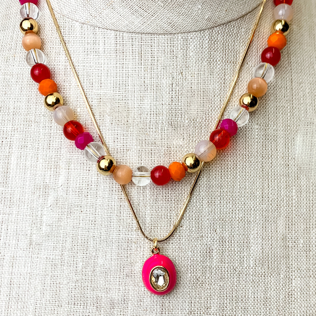 This Multicolored Layering Necklace with an Oval Pendant id pictured on an ivory mannequin with a white background.