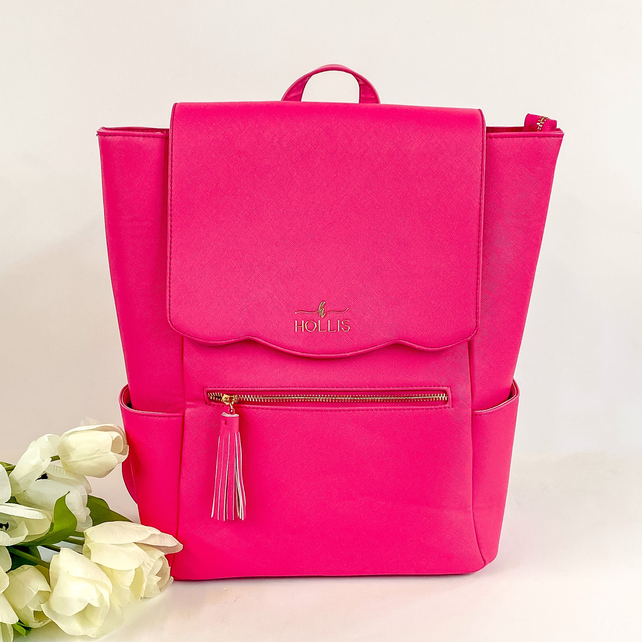 Hollis brand full size backpack in a hot pink color. Has a gold zipper and tassel on the zipper. Pictured on a white background.
