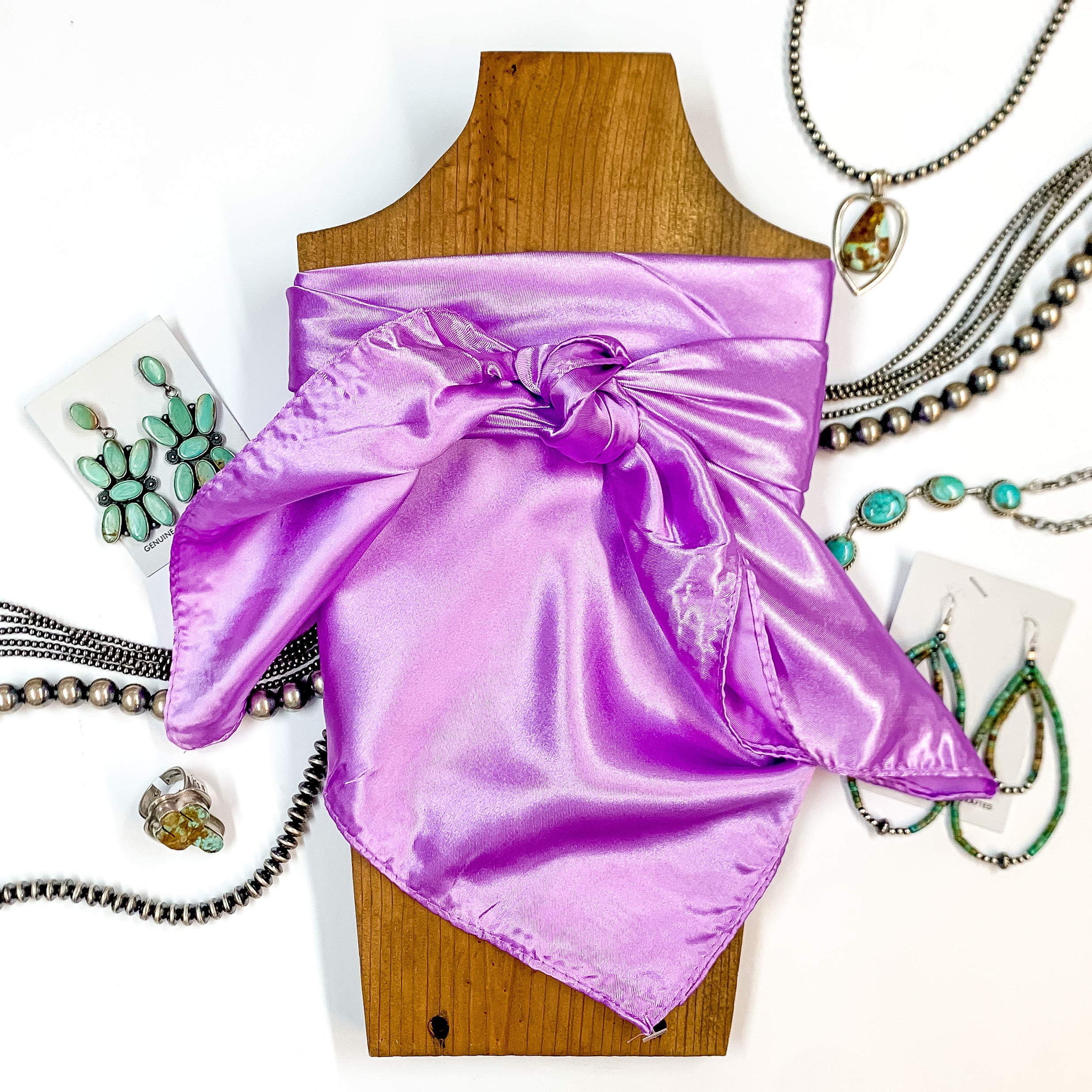 Solid colored scarf in Pastel Purple. Scarf is tied around a wooden piece. The scarf and piece of wood is pictured on a white background with Navajo jewelry spread out around it.