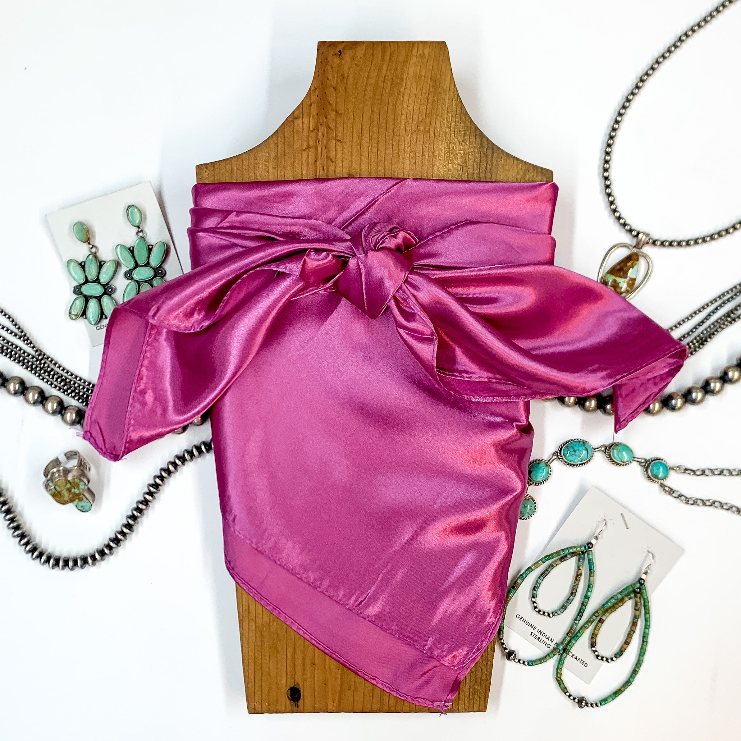Solid colored scarf in Mauve. Scarf is tied around a wooden piece. The scarf and piece of wood is pictured on a white background with Navajo jewelry spread out around it.