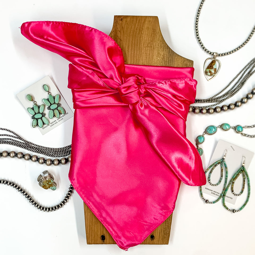 Solid colored scarf in Hot Pink. Scarf is tied around a wooden piece. The scarf and piece of wood is pictured on a white background with Navajo jewelry spread out around it.