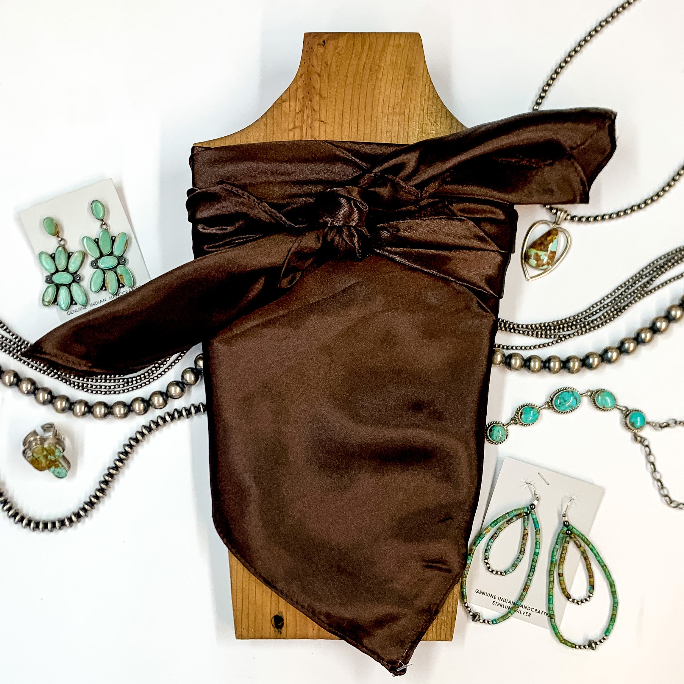 Solid colored scarf in Dark Coffee. Scarf is tied around a wooden piece. The scarf and piece of wood is pictured on a white background with Navajo jewelry spread out around it.