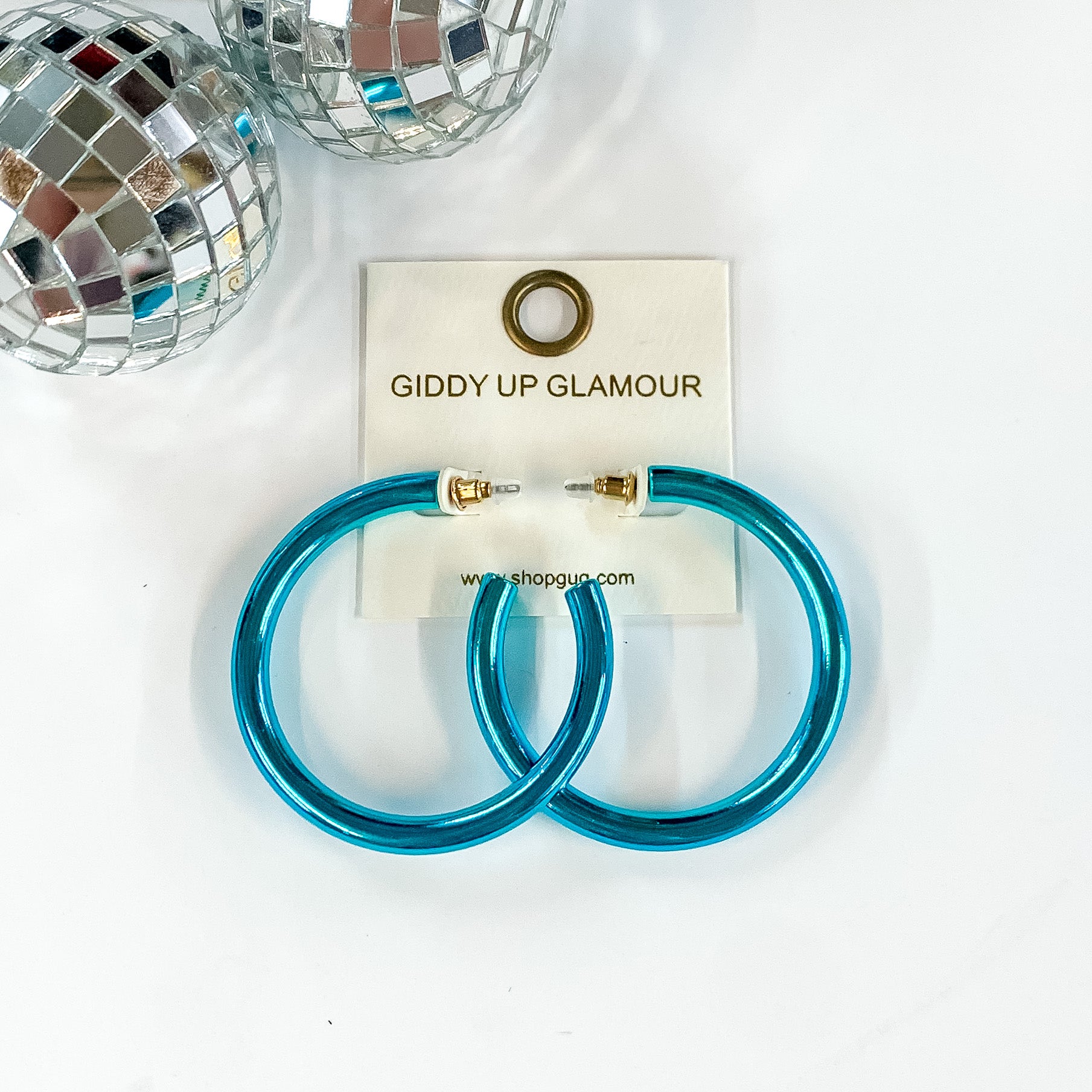 Light Up Large Neon Hoop Earrings In Blue. Pictured on a white background with disco balls in the top left corner.