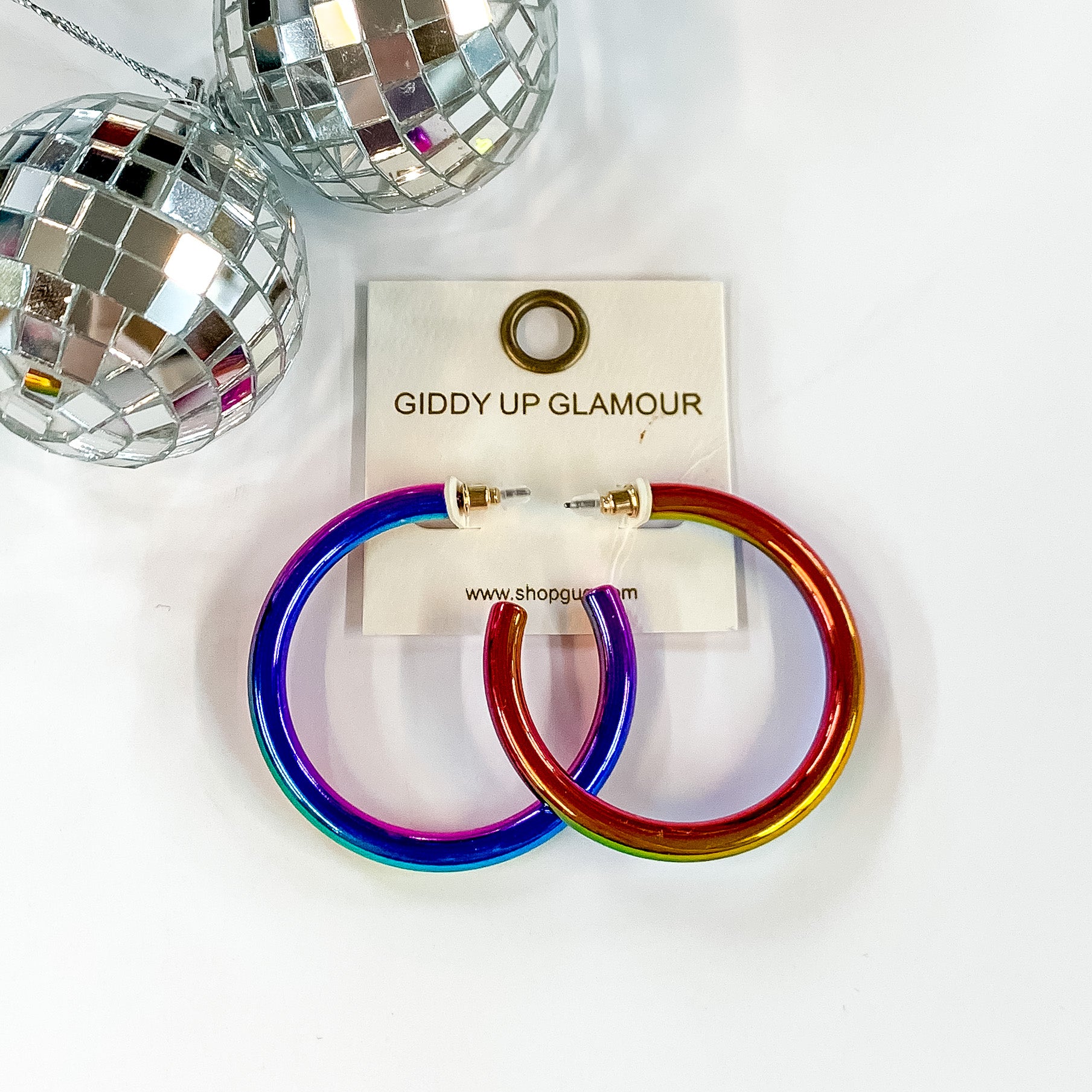 Light Up Large Neon Hoop Earrings In Multicolored. Pictured on a white background with disco balls in the top left corner.