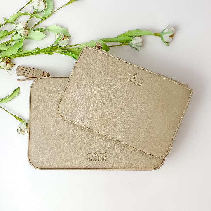 Nude jewelry totes pictured on top of each other. These bags are pictured on a white background with green and white flowers in the background. 