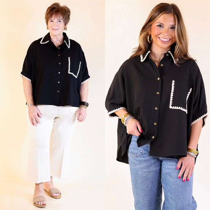 Two women wearing black button-up shirts with white trim, one in cream pants and the other in jeans, on a plain background.