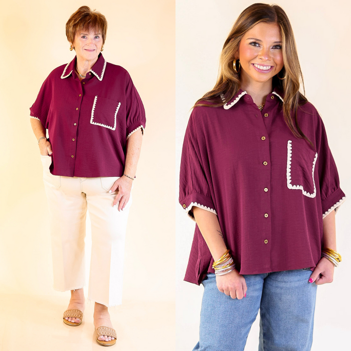 Two women wearing maroon button-up shirts with white trim on a plain background