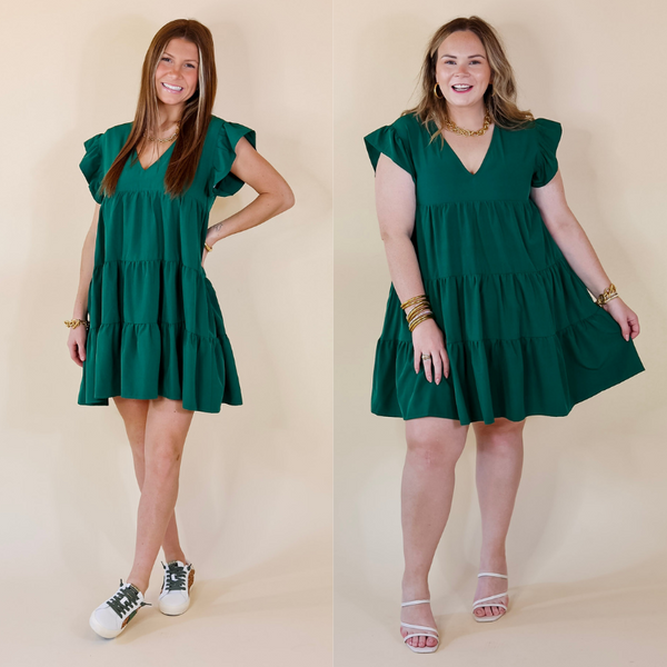 Models are wearing an hunter green, tiered dress, with ruffle cap sleeves. Models have paired to dress with gold tone jewelry, white and green sneakers, and white strappy heels. 