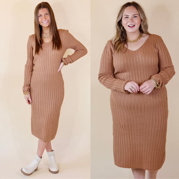 In the picture the model is wearing a v neck midi sweater dress in a clay nude color with a white background