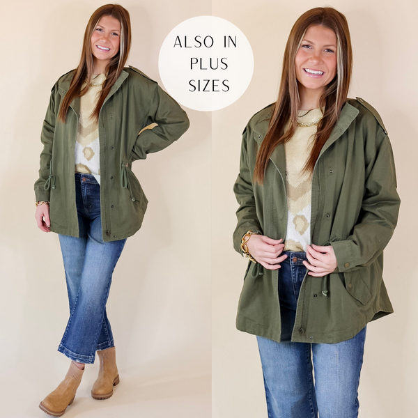 In this picture the model is wearing a button and zip up utility jacket in olive green with a white background