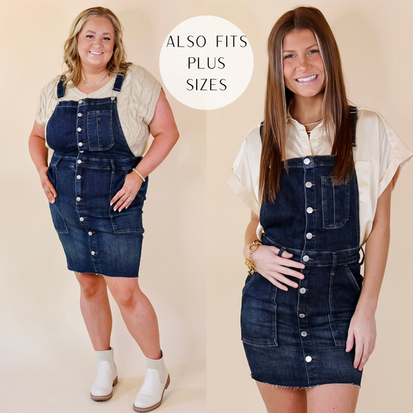 in the picture the model is wearing a denim overall dress in a dark wash color with a white background