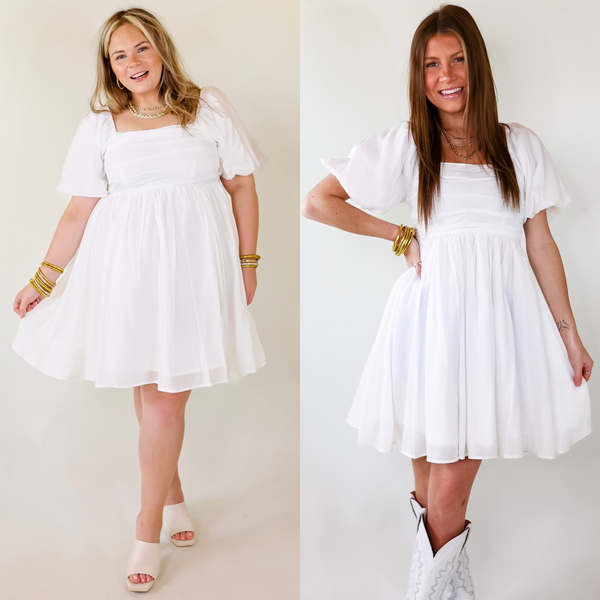 A flowy white dress featuring off the shoulder sleeves, puffed sleeves,and pleated body/skirt.