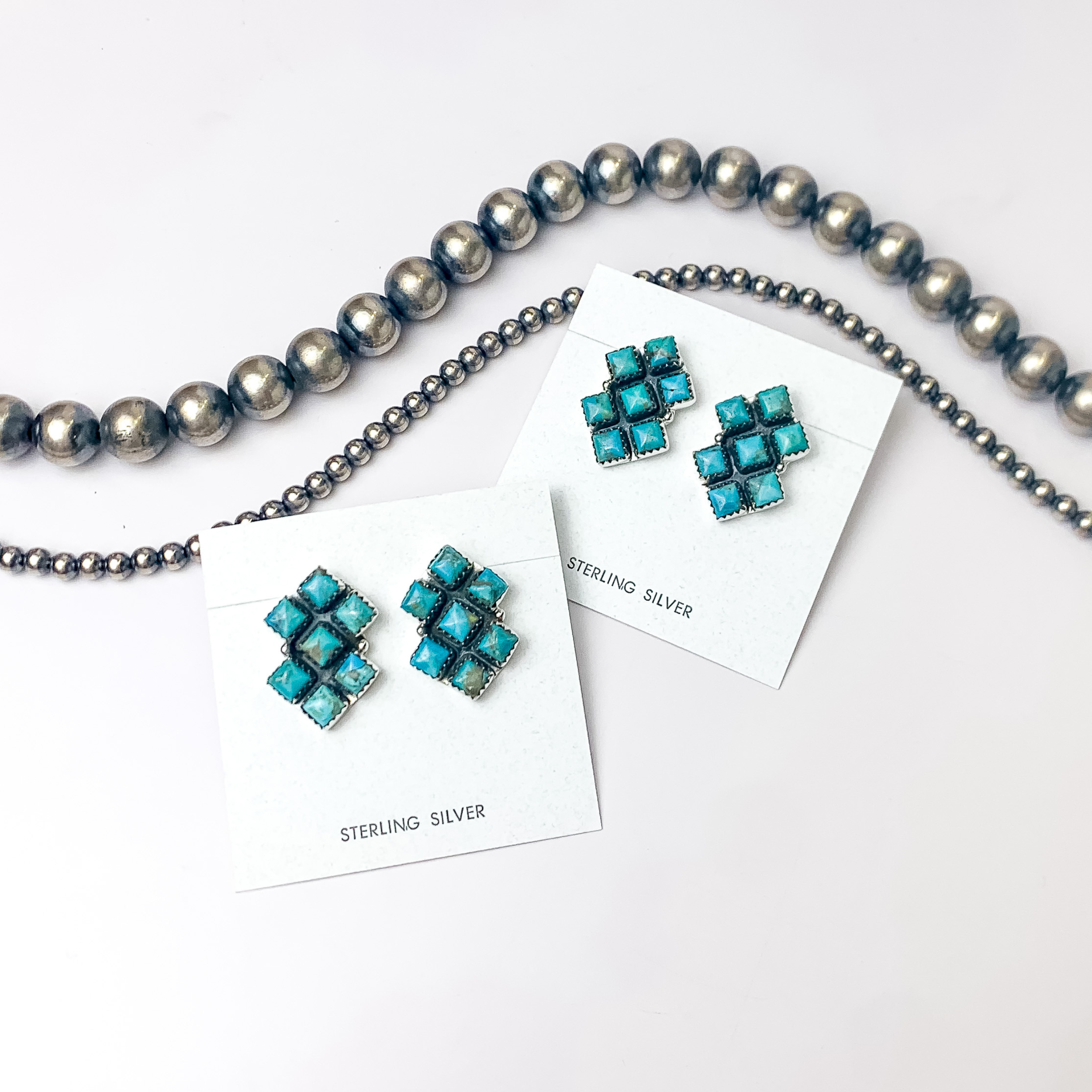 In the picture are cluster square earrings in kingman turquoise with a white background 