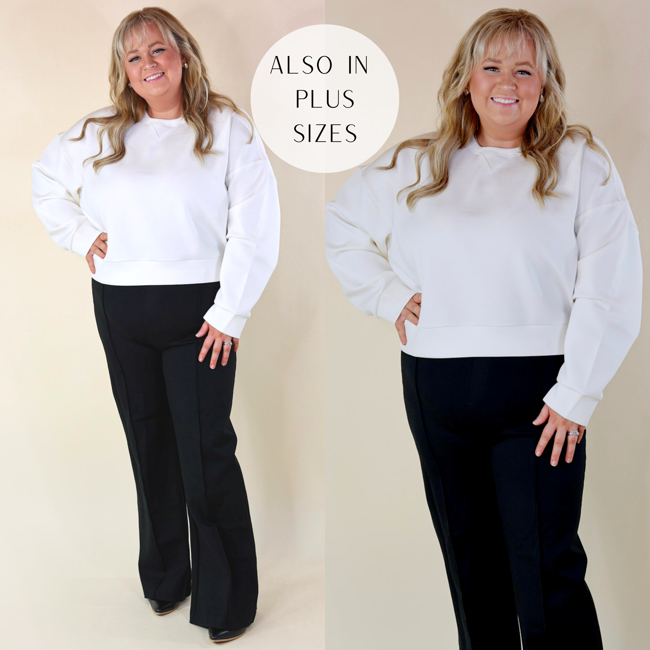 In the picture the model is wearing spanx airessentials crew neck pullover sweatshirt in a powder white color and has paired is with black pants and boots with a white background.