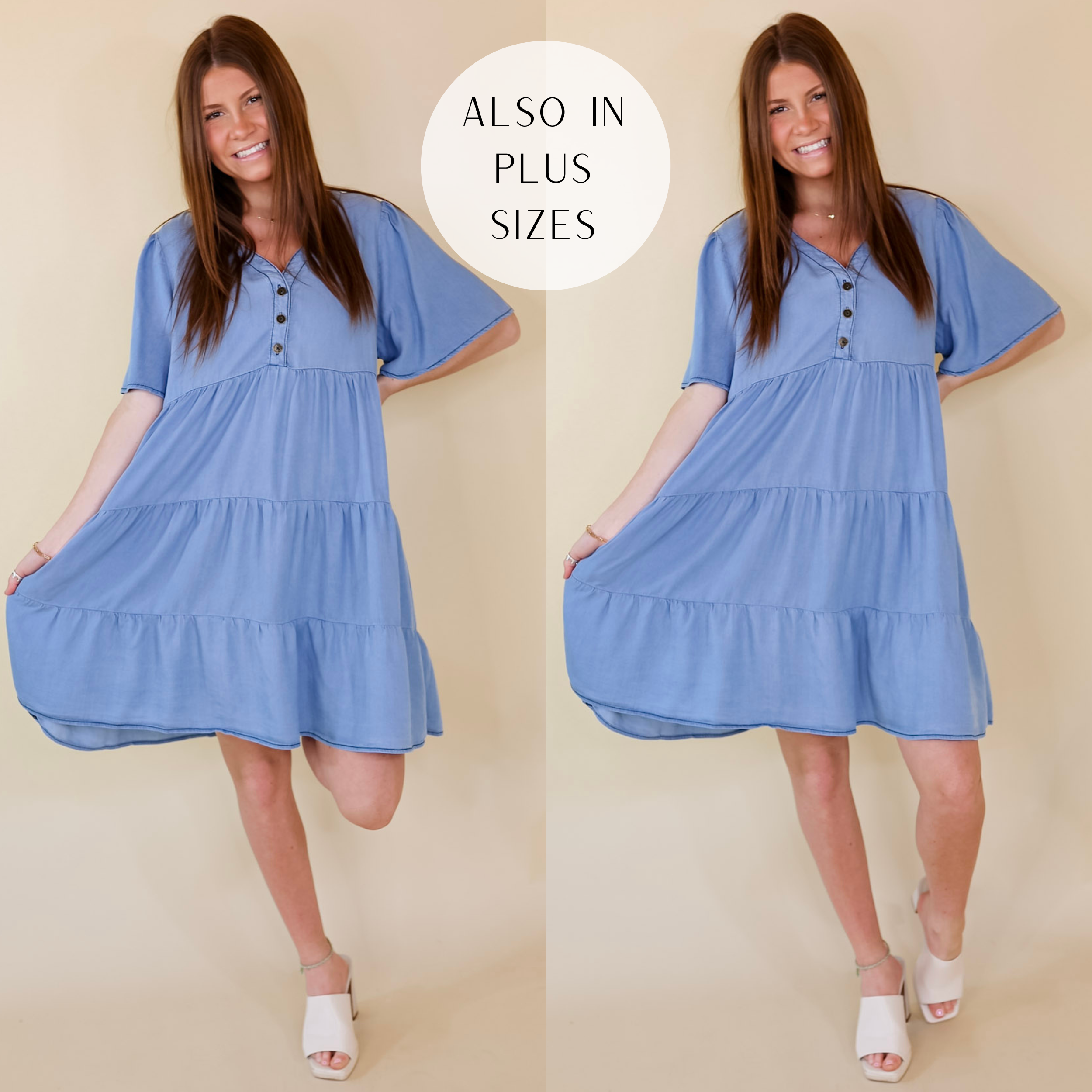 A light wash short sleeve dress with buttons, a V neckline, tiered skirt, flowy sleeves, and a relaxed fit. Item is pictured on a pale pink background.