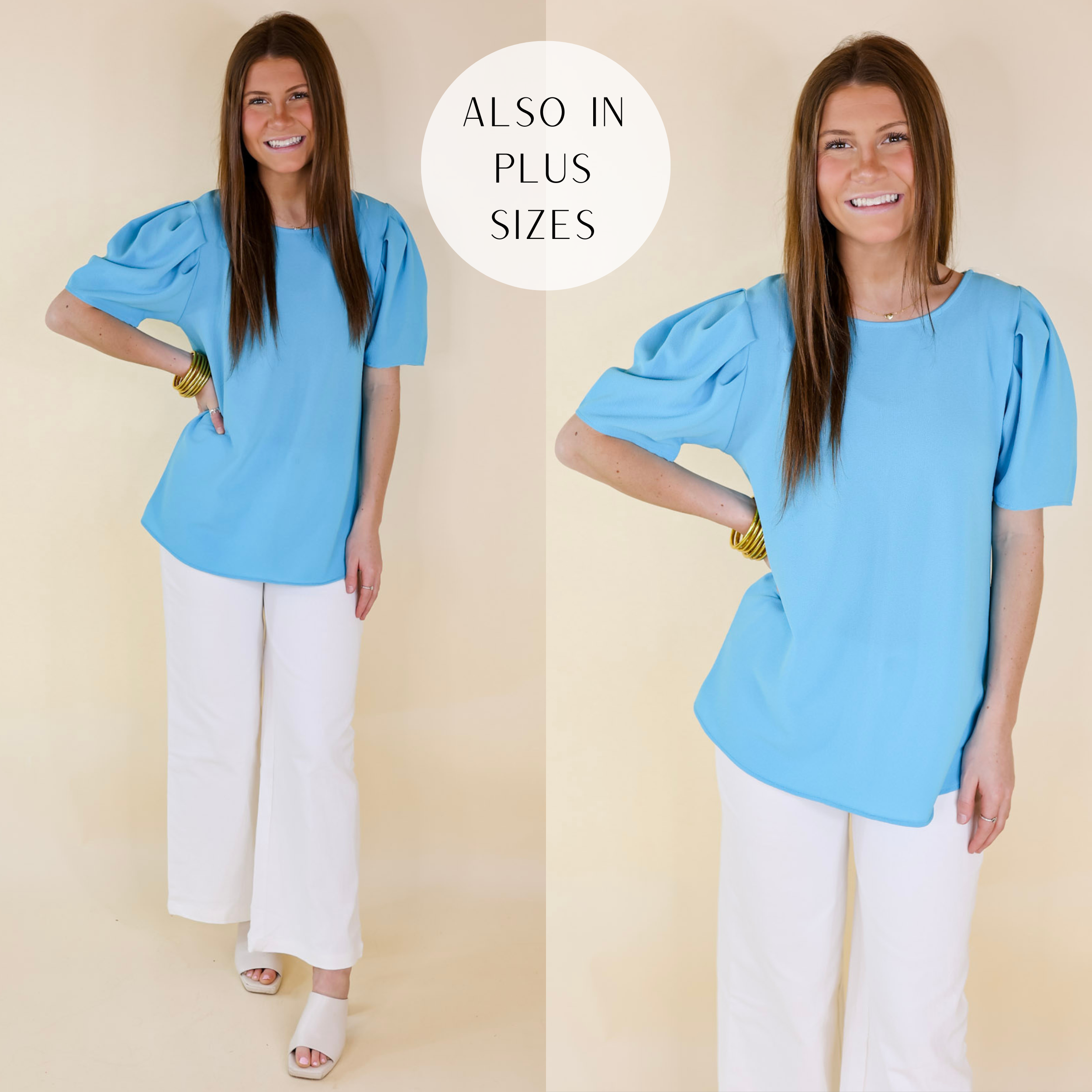 Model is wearing a short sleeve top with pleated detail on the shoulder. Model has this blue top paired with light wash jeans, ivory heels, and gold jewelry.