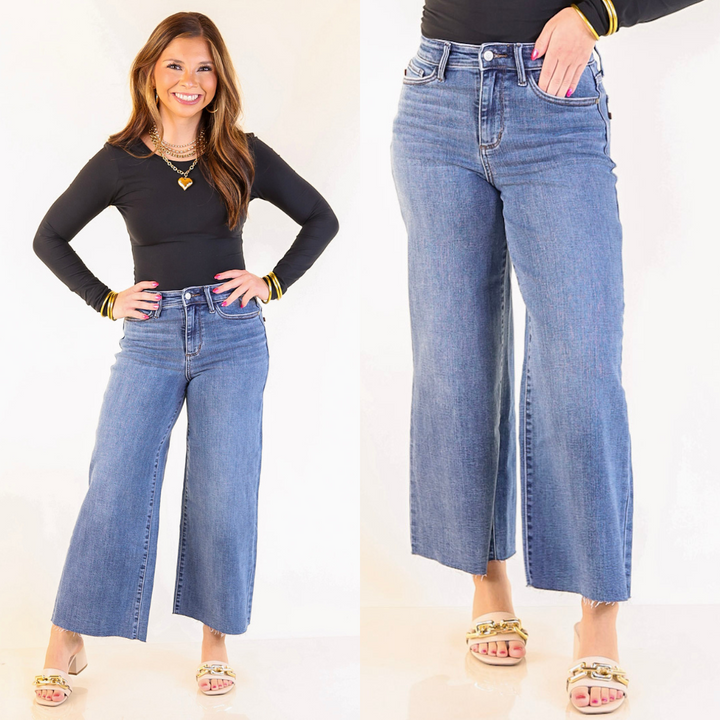 Woman wearing blue wide-leg jeans with a plain background