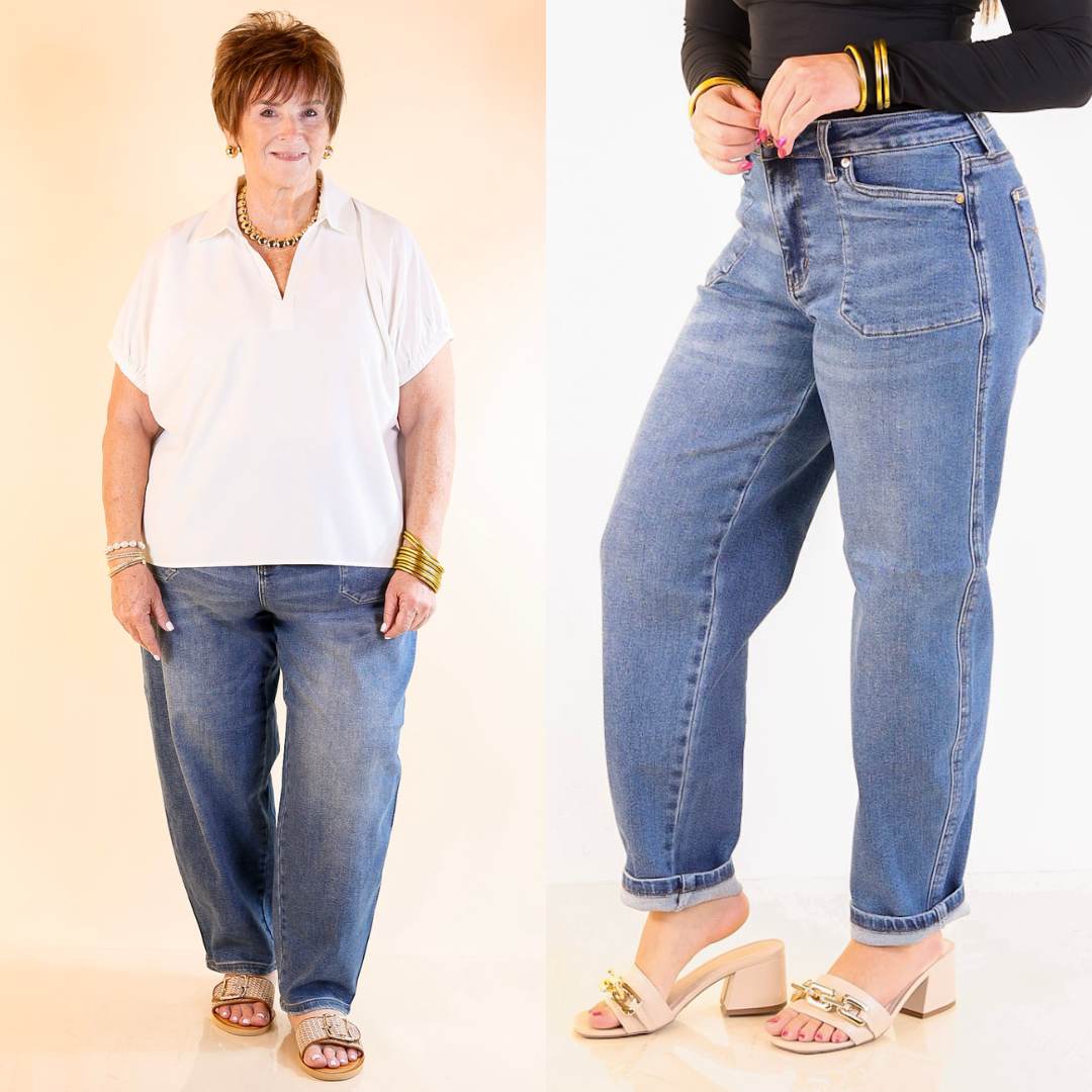 Woman wearing barrel blue jeans with a plain background