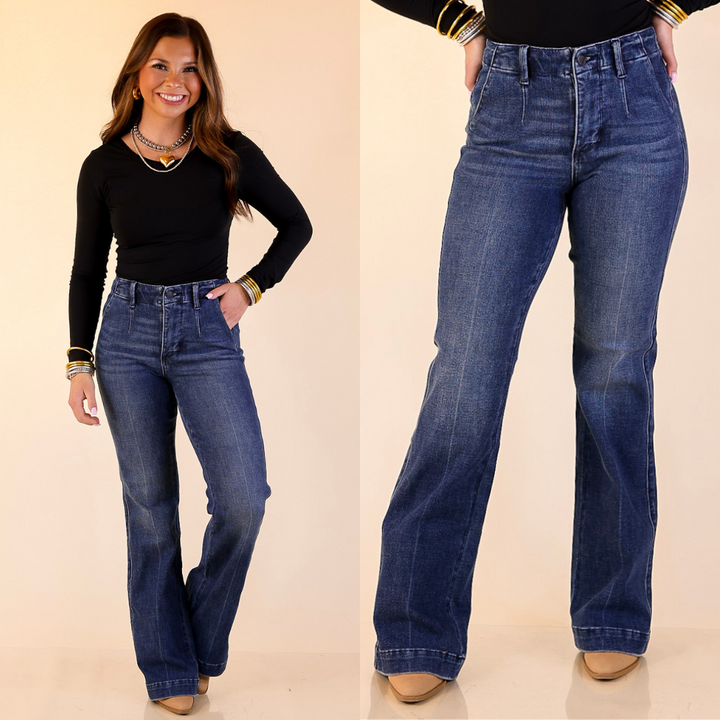 Woman wearing bootcut trouser blue jeans with a close-up of the jeans on a beige background