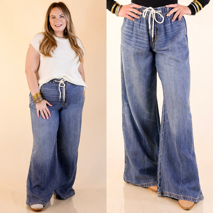 Model is wearing Wide Leg Palazzo Elastic Waistband Jeans in Dark Wash with a plain background