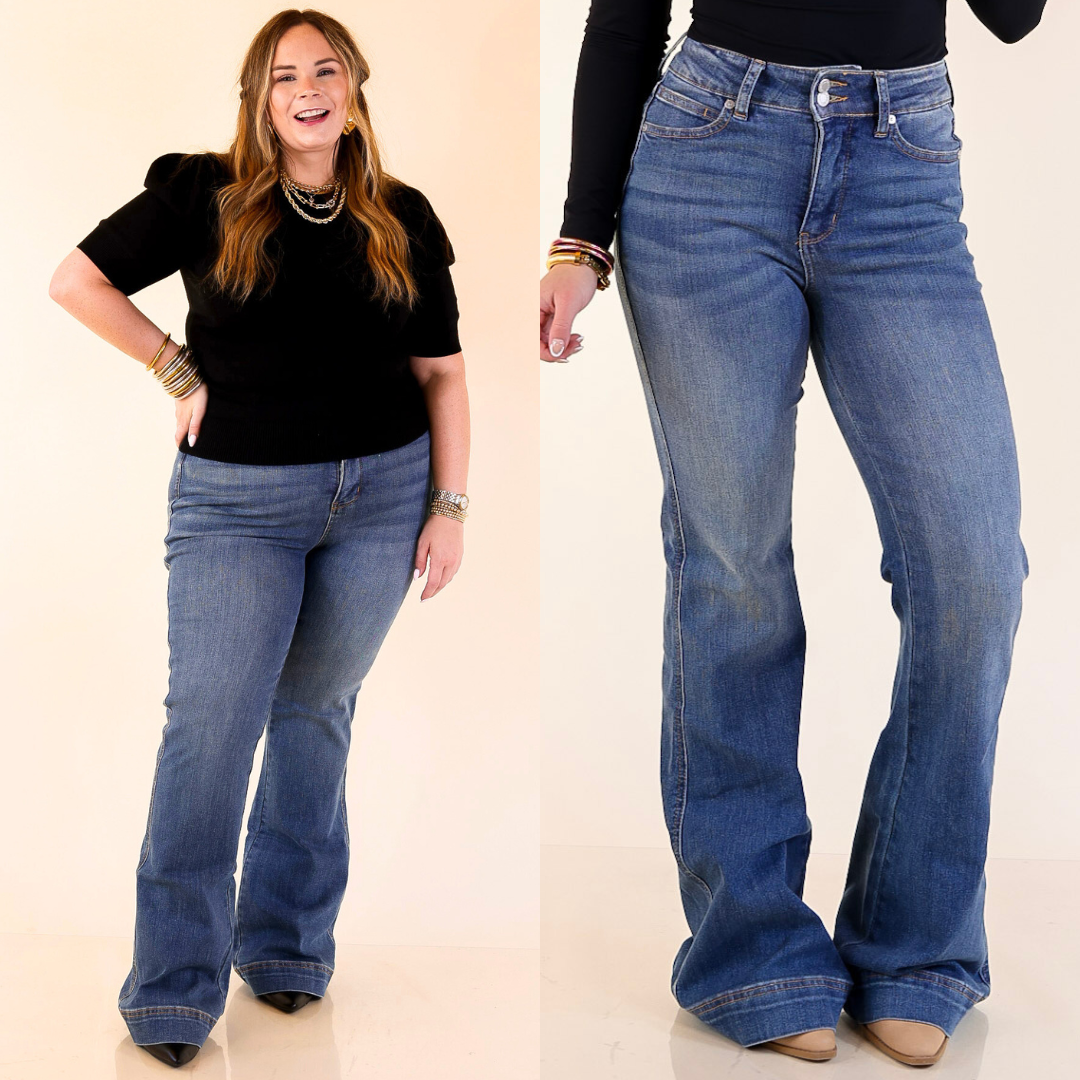 Woman wearing flare blue jeans with a plain background