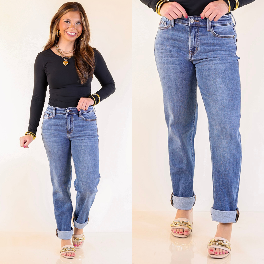 Woman wearing boyfriend blue jeans with a plain background