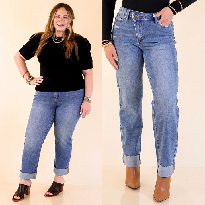 Woman wearing boyfriend blue jeans with a plain background