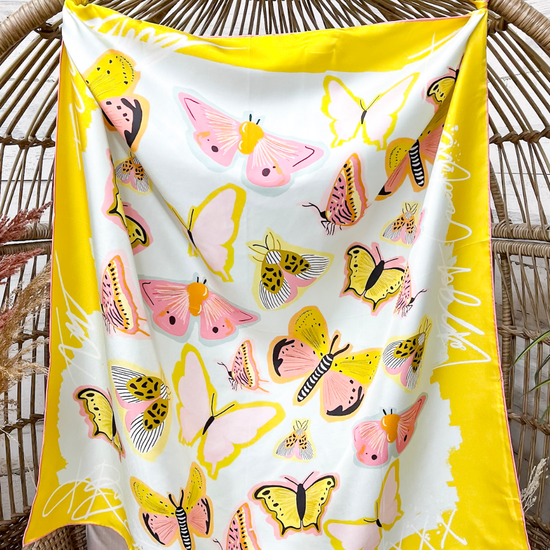 Yellow Butterfly scarf in front of a wicker chair