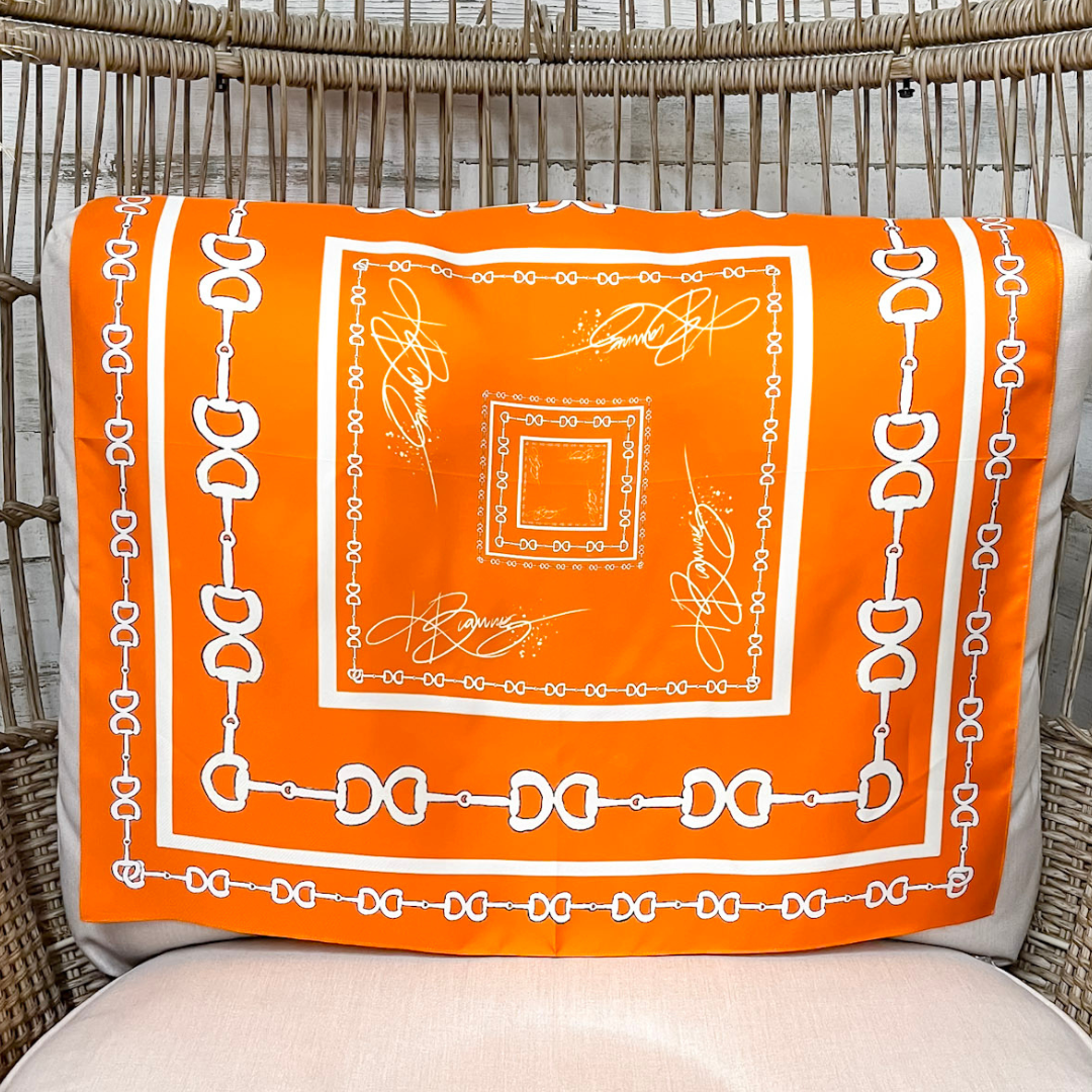 Orange scarf with white patterns on a chair