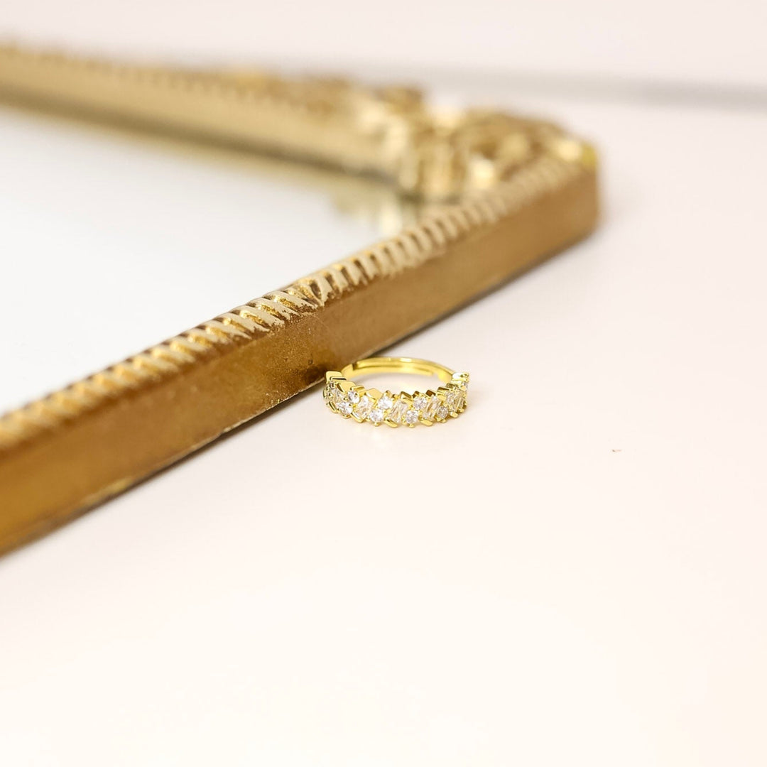 Gold ring on a white surface with a gold frame