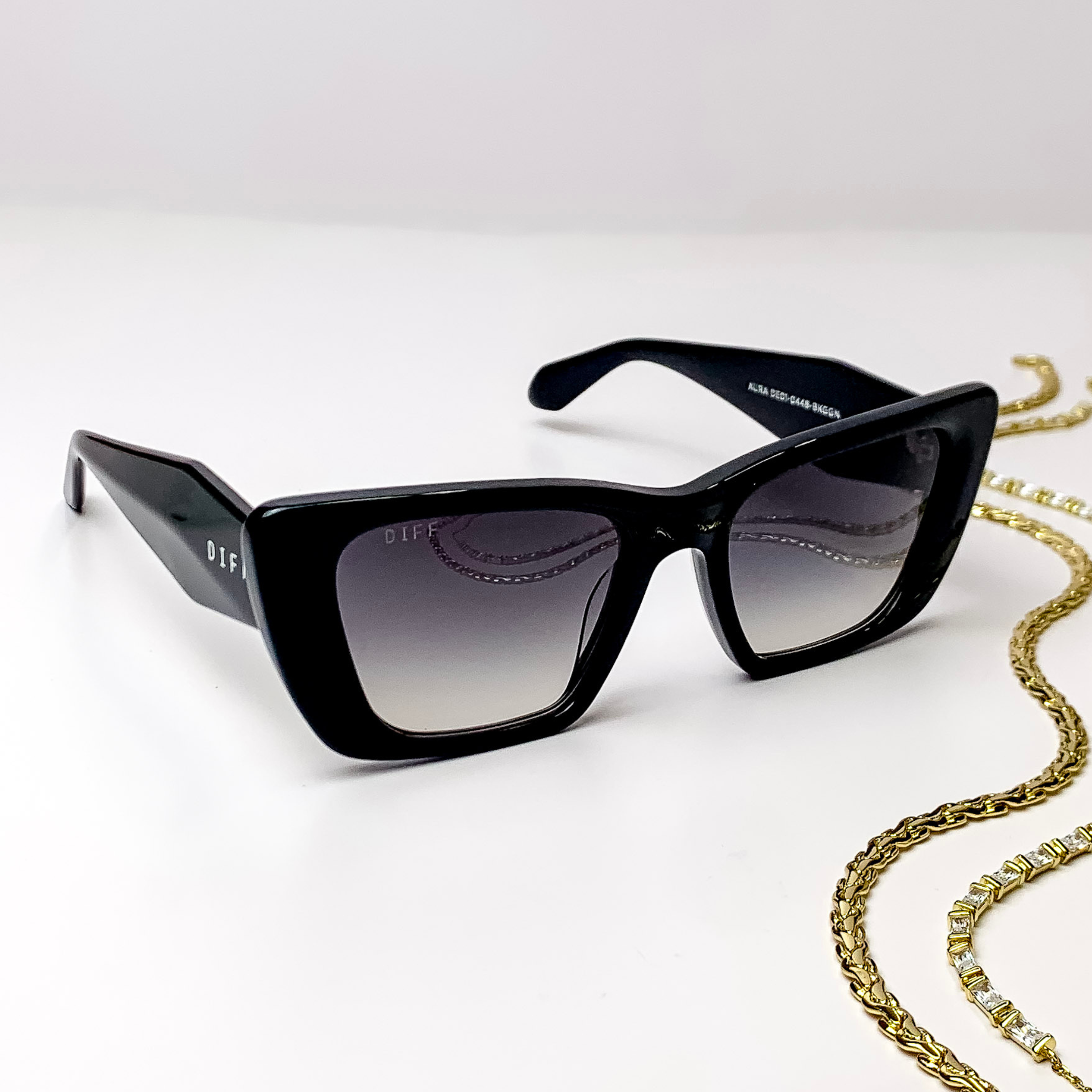 Square black cat eye glasses with a thick frame, thick temple, and grey gradient lenses