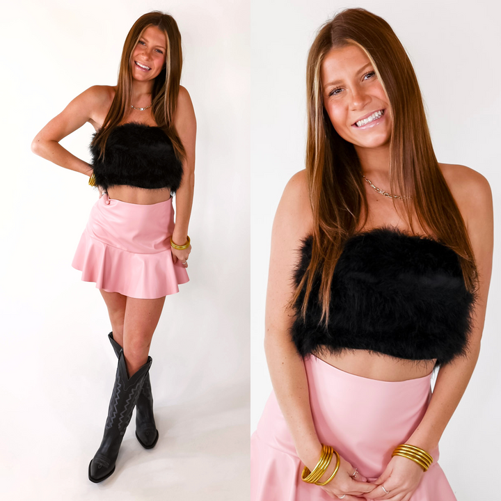 Model is wearing a black strapless feather crop top.