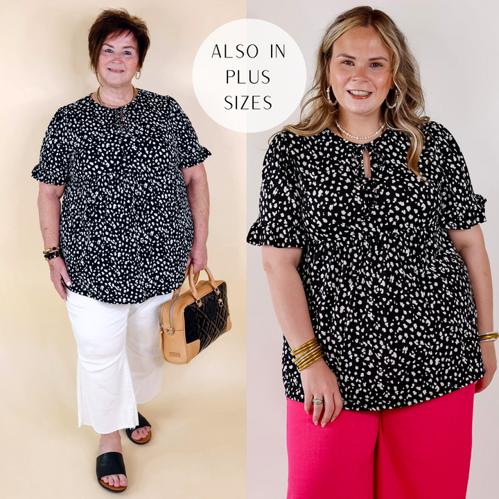 Model is wearing a black babydoll top with short sleeves, a keyhole and tie neckline, and a white leopard print all over.