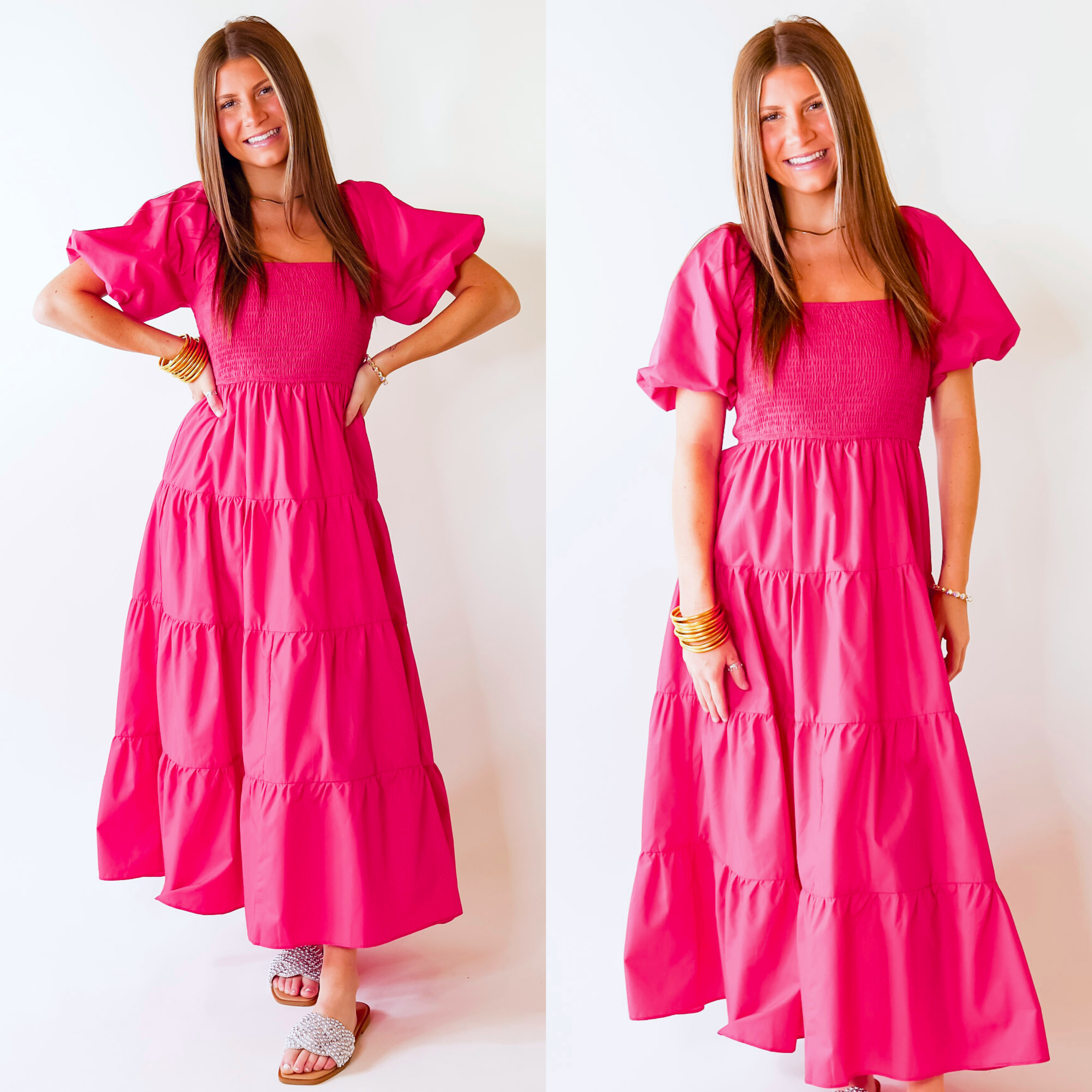 Model is wearing a long pink dress featuring puffed balloon sleeves, smocked bodice, and tiered skirt.