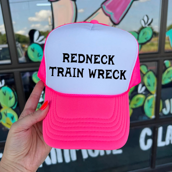 In this picture is a trucker foam hat that says redneck trainwreck across the top of it in pink and white colors