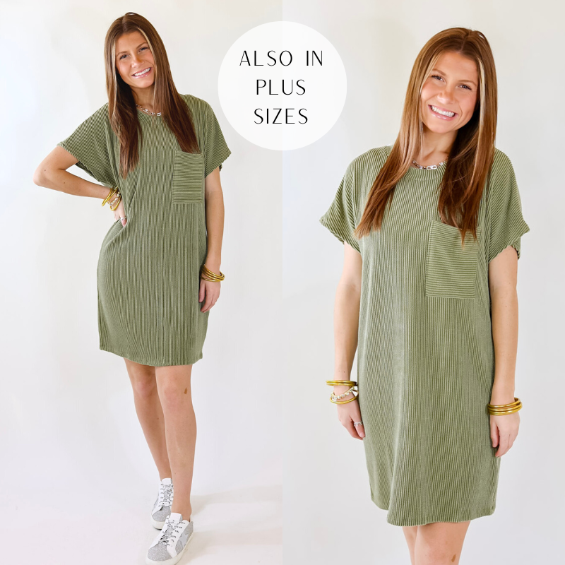 Model is wearing an olive green ribbed short sleeve dress with a front pocket. Model has paired the dress with white and silver sneakers and gold jewelry. 