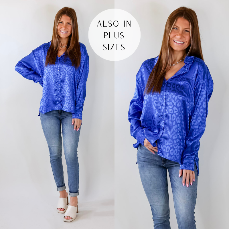 Model is wearing a blue satin long sleeve button up with leopard print on it. Model has paired the top with skinny jeans, ivory heels, and a gold tone necklace. 