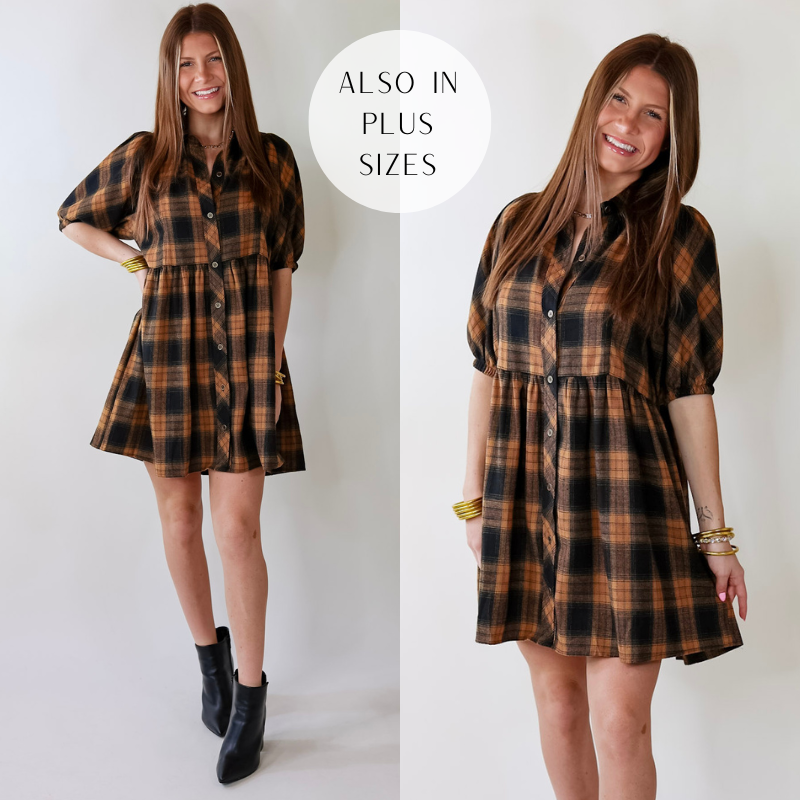 Model is wearing a camel brown and black plaid button up dress. Model has paired the dress with black booties and gold tone jewelry. 