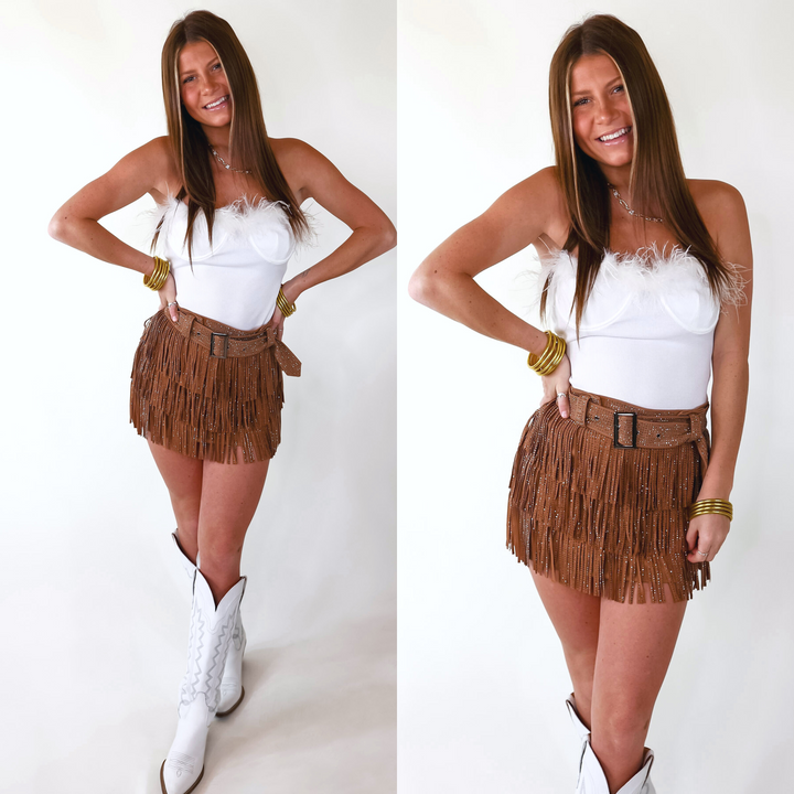 Model is wearing a white ribbed bodysuit featuring feathers lining the bust