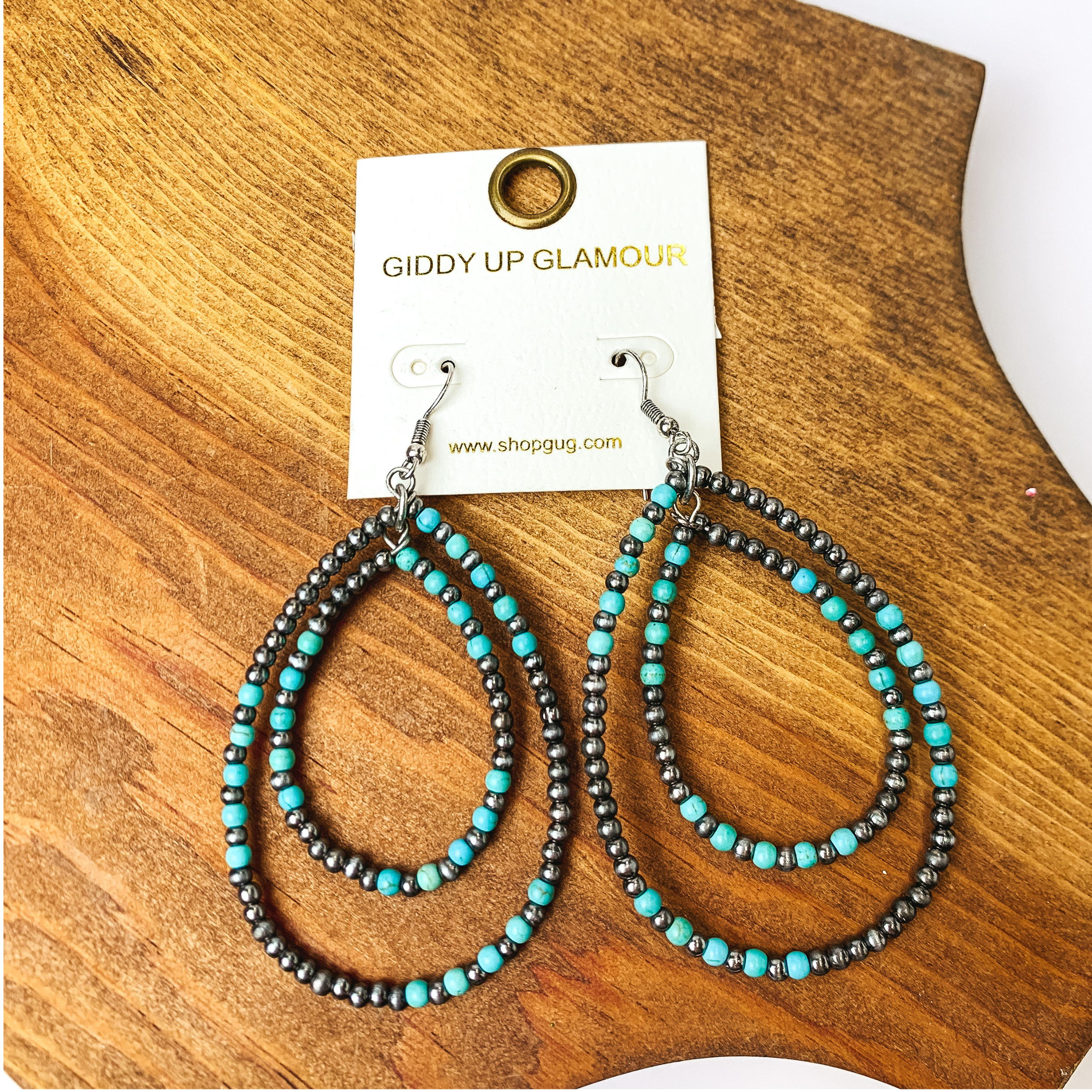 Beaded Open Double Drop Earrings in Silver Tone and Turquoise. Pictured on a wood piece.