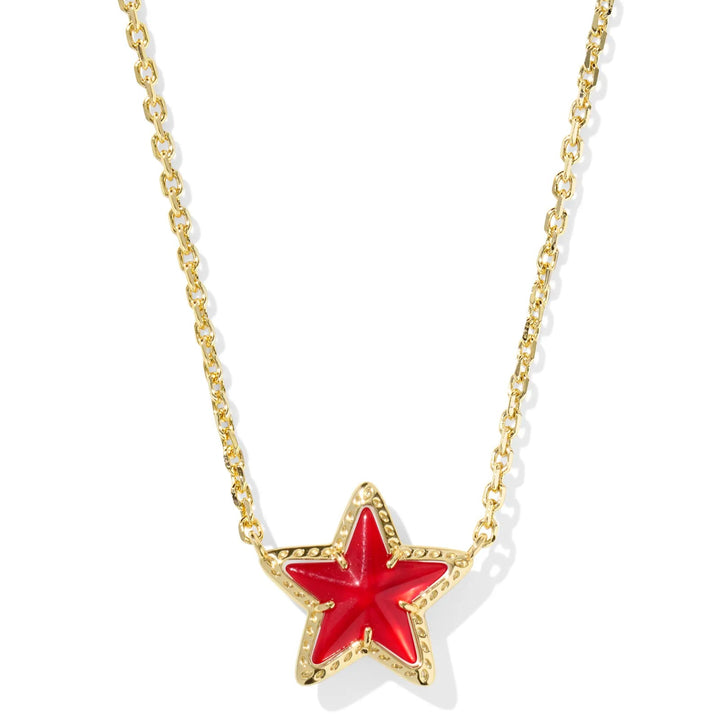 Solid white background with a gold chain necklace and a ed star pendant. 