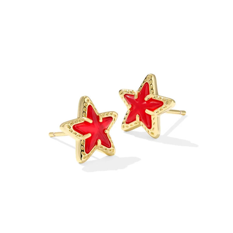 Solid white background with red start stud earrings in gold tone