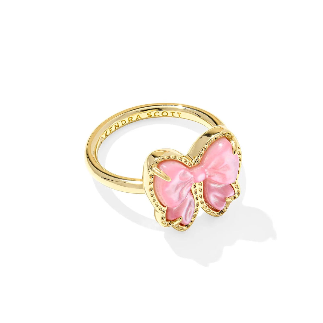 Gold ring with a pink bow on a white background