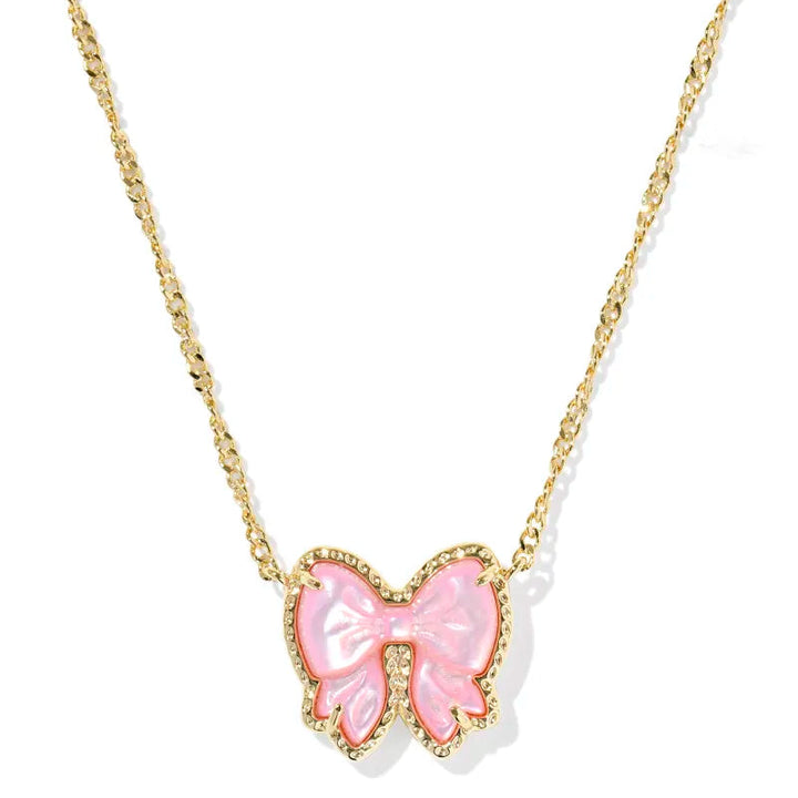 Pink bow pendant on a gold chain against a white background