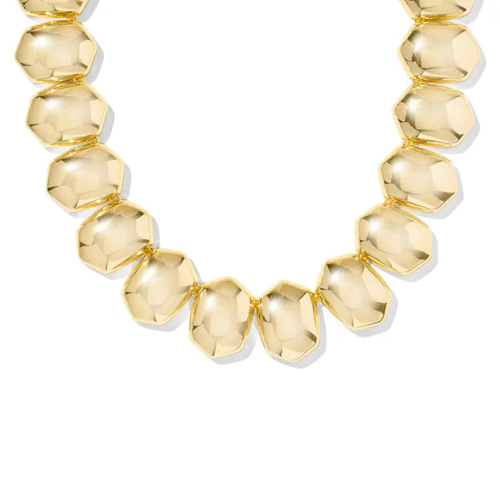 Gold necklace with faceted beads on a white background