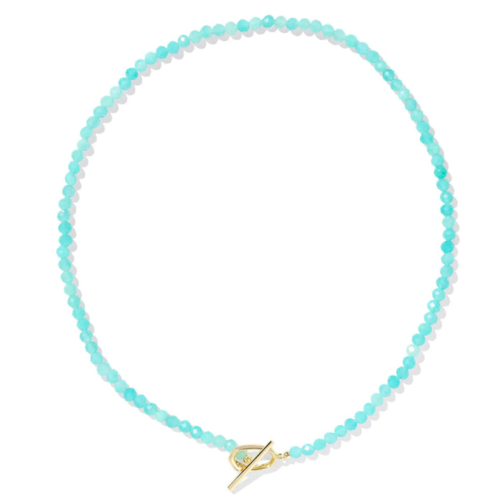 A solid white background with a teal beaded necklace and gold hinge link.