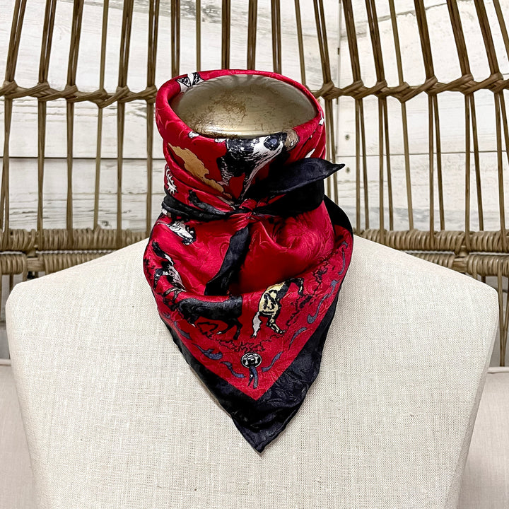 Mannequin wearing a red and black patterned bandana on a wicker chair.